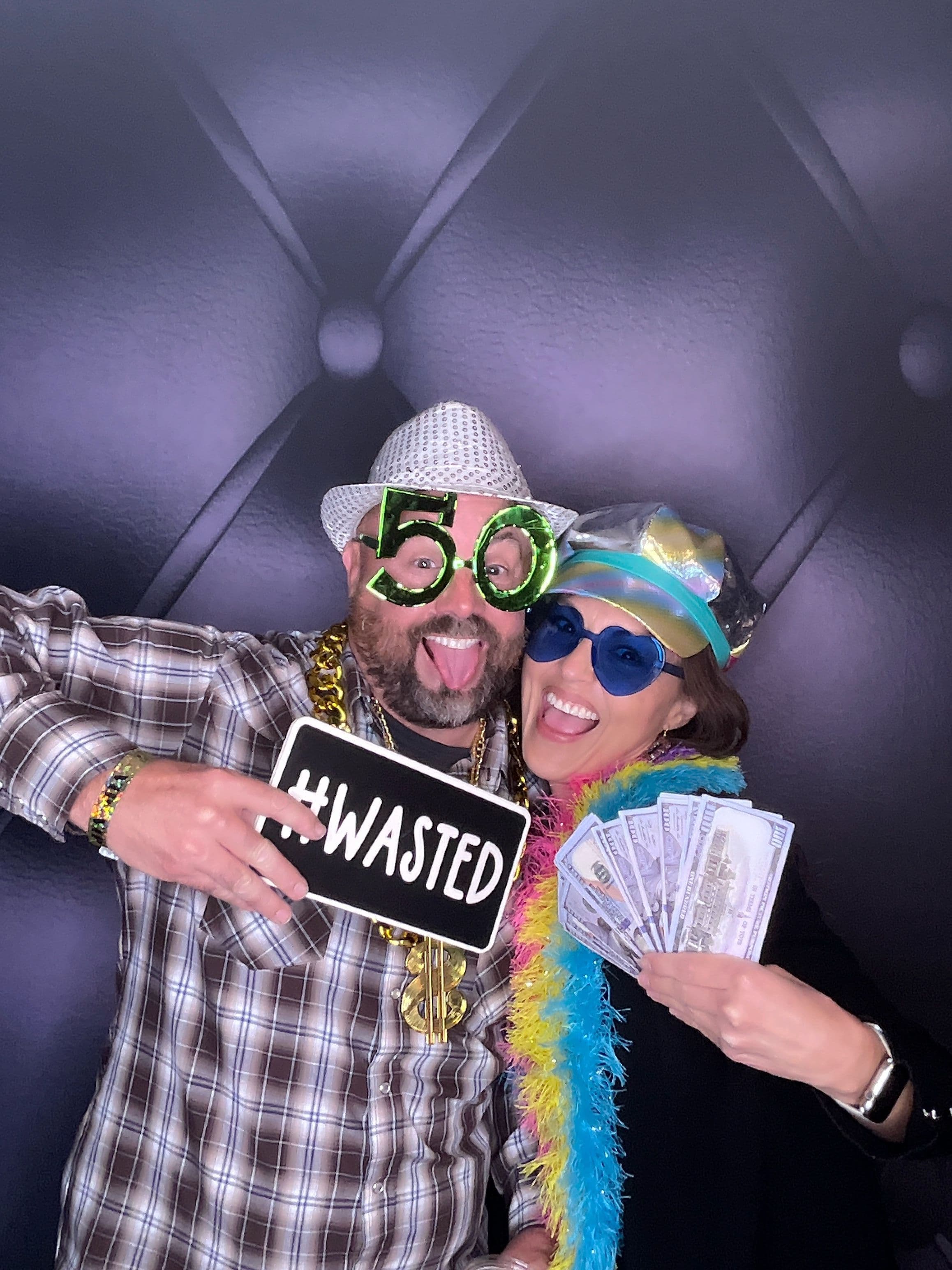 A group of guests holding photo booth props at a birthday event. 