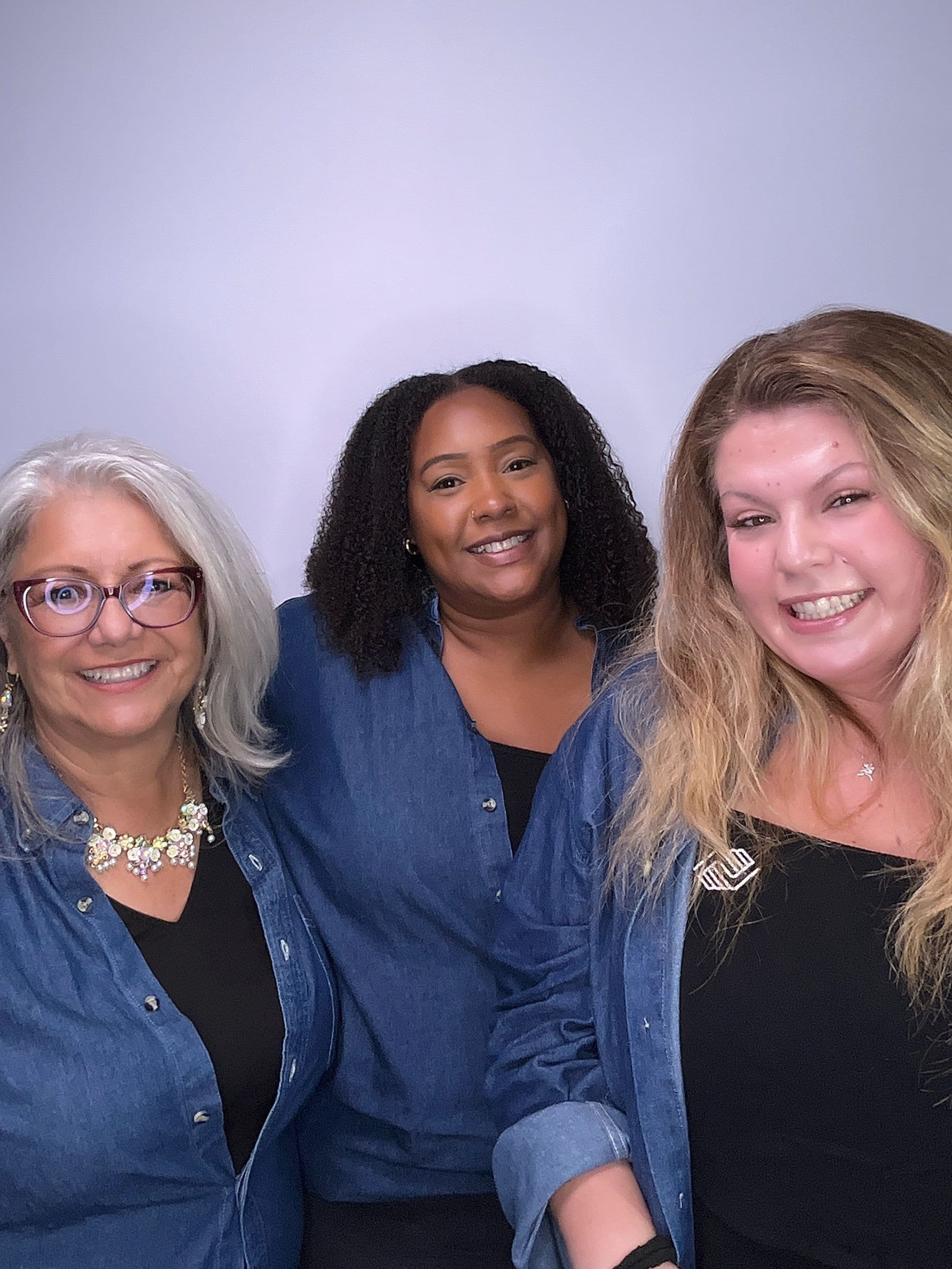 Three adults posing in front of a white backdrop at a Gala event in Fontana