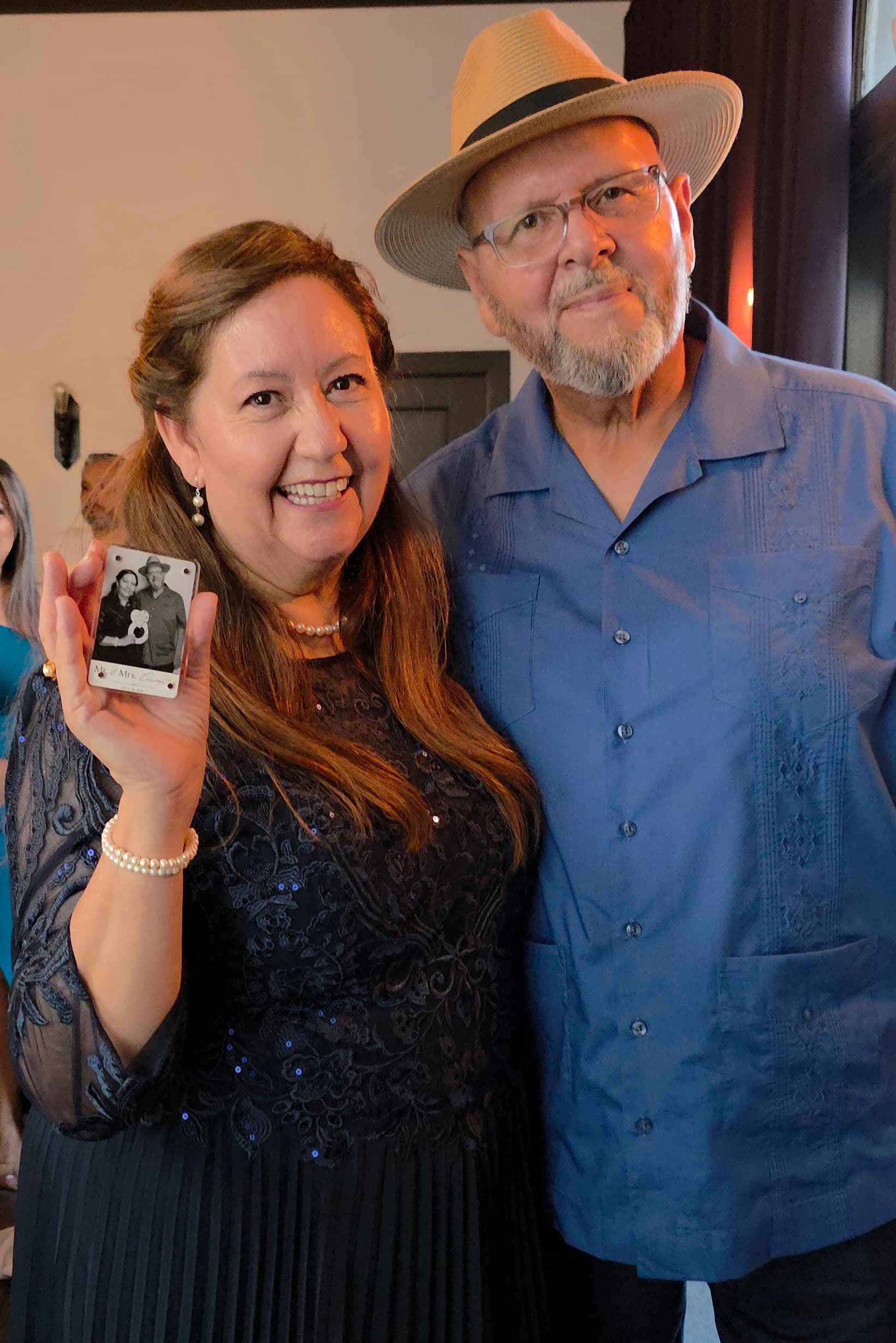 Two guests at a wedding venue in Fontana holding their magnet keepsake